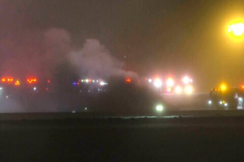 This image taken from video provided by WABI television, emergency services work on a scene of the Bombardier Challenger 600 crash at the Bangor Airport in Maine, late Sunday, Jan. 25, 2026. (WABI via AP)