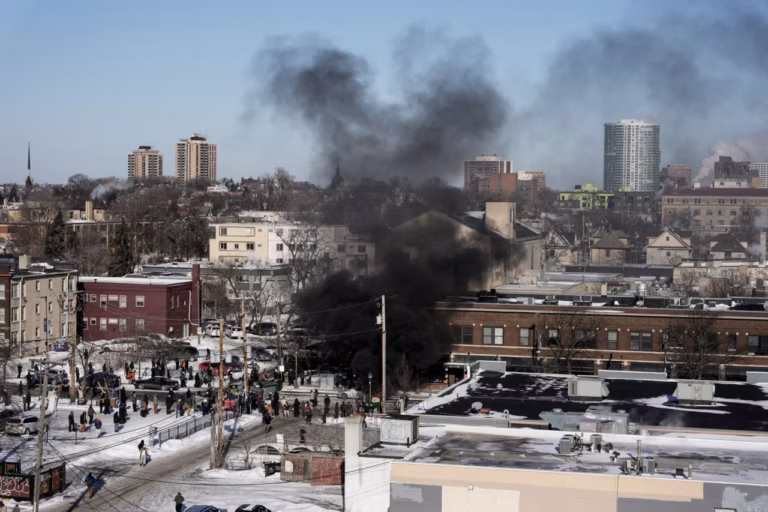 Smoke from burning dumpsters rises, during clashes between federal agents and community members in Minneapolis, on Saturday. Tim Evans/Reuters