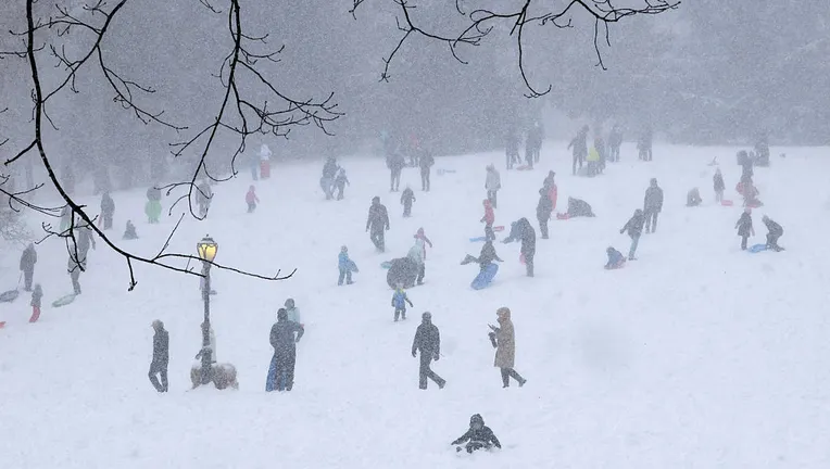 FILE-People go sledding in the snow at Cedar Hill in Central Park in New York City on January 25, 2026. (Photo by TIMOTHY A. CLARY / AFP via Getty Images)